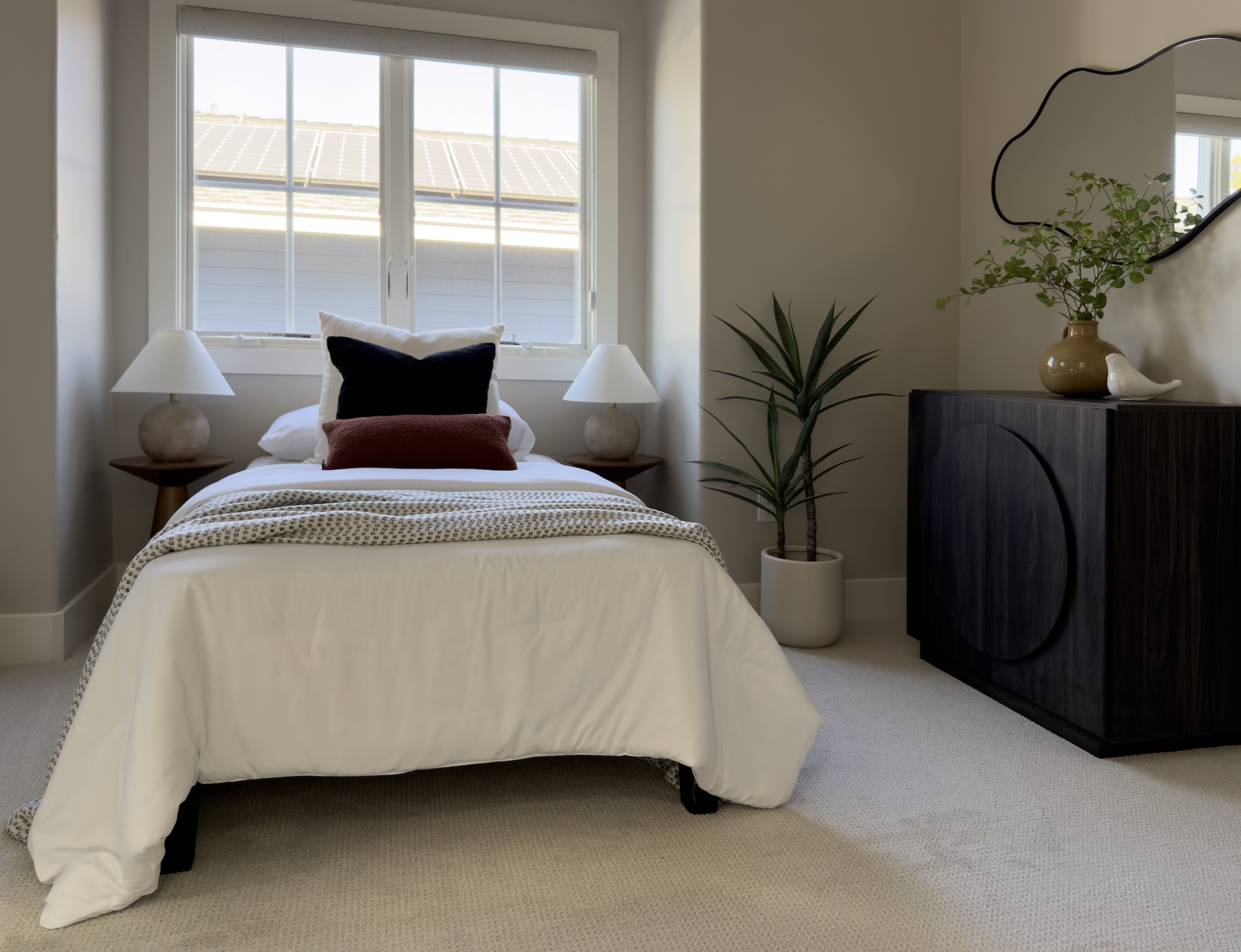 Bedroom with white bedding and black cabinet