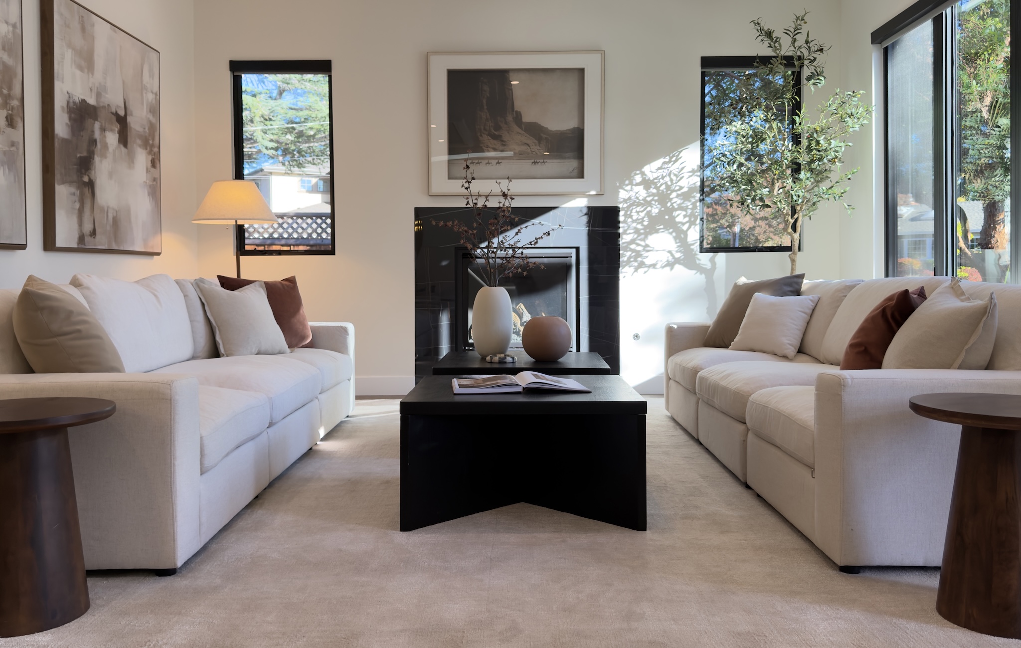 Staged living room with twin sofas facing a black coffee table