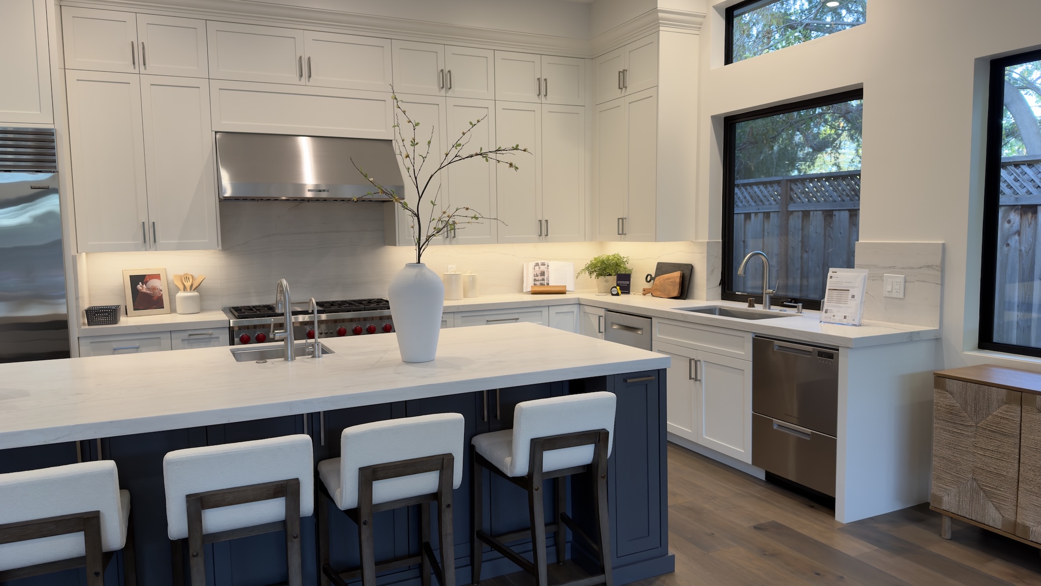 White kitchen with navy island and counter stools